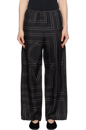 Totême Pantalon de détente de style pyjama noir en soie à monogrammes